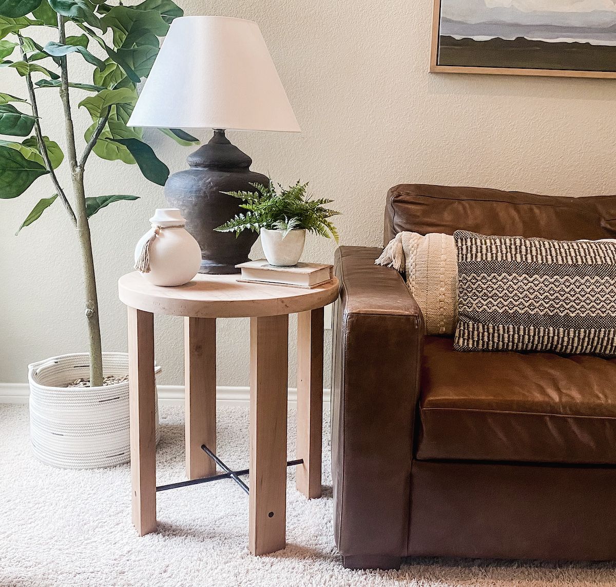 Modern casual living room with small round end table next to leather couch.